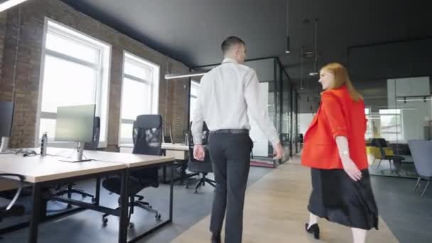 モダンなスタートアップオフィスを歩き さまざまなビジネス課題についてダイナミックな議論に取り組む2人の若いビジネス同僚 — ストック動画