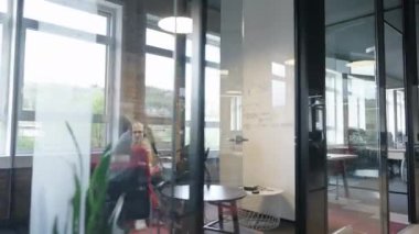 Çeşitli meslekdaşlar, takım çalışması ve yenilikçi teknoloji yoluyla iş dünyasındaki zorluklarla başa çıkmak ve üretkenliği artırmak için dizüstü bilgisayarlar, cep telefonları ve tabletler kullanarak iş birliği yaparlar.