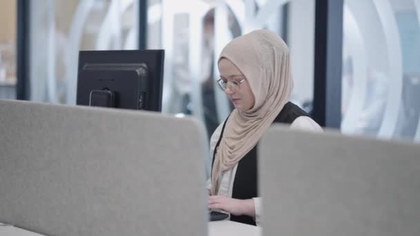 Nowoczesnym Biurze Muzułmański Przedsiębiorca Hidżabie Siedzi Pewnie Pilnie Pracuje Swoim — Wideo stockowe