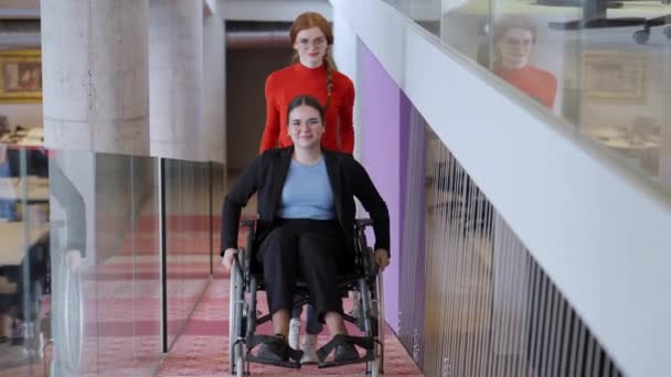 Şefkatli Bir Kadını Ofislerinin Yanından Geçen Tekerlekli Sandalyedeki Bir Meslektaşına — Stok video