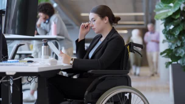 휠체어를 사업가가 사무실에서 노트북으로 작업하는 모습을 포괄성 접근성 전문성을 중요하게 — 비디오