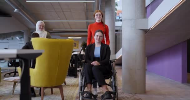 一位富有同情心的女商人在一位坐轮椅的同事走过她们的办公室和同事身边时 向他们提供了支持 这说明了他们的包容性 团队精神和同情心等价值观 — 图库视频影像