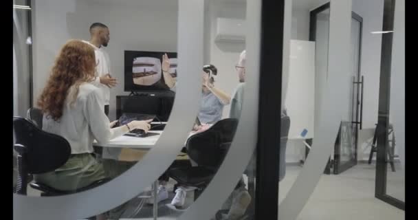 多様なビジネスマンが協力し 新しい仮想現実テクノロジーをテストし 仮想メガネを着用し 未来的なワークスペースでイノベーションと創造性を示しています — ストック動画