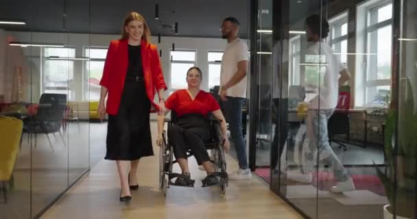 若い女性起業家は 彼女の状態のために車椅子を使用して 近代的で包括的なオフィスをナビゲートし 職場での決意とエンパワーメントを示しています — ストック動画