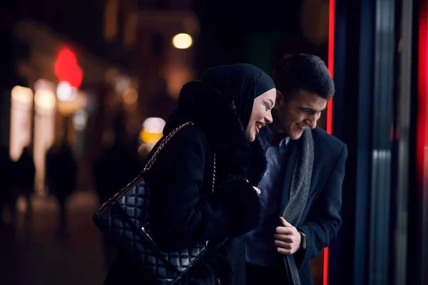 快乐的多文化商业伙伴晚上一起走在城市街道上的珠宝店橱窗旁 成功的阿拉伯商人和欧洲穆斯林妇女 — 图库照片