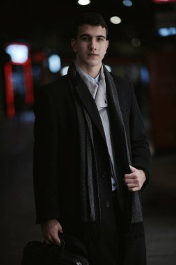 Gülümseyen Meedle Eastern adamı modern ofis binasının yakınındaki caddede yürüyor, serbest çalışan işadamı geceleri işlek şehir caddesinde elinde cep telefonuyla diğer tarafa bakıyor.