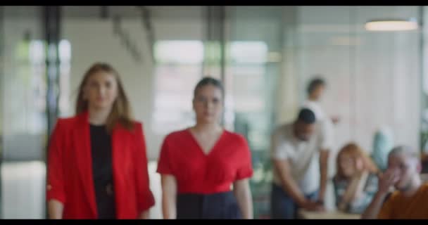 近代的なスタートアップスペースの廊下を通り抜ける自信あるビジネスマンのチームは 仕事への献身を伝えるために クロスアームで自信を持った決意を示しています — ストック動画