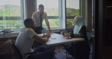 Çeşitli iş arkadaşları, modern bir girişim ofisindeki iş arkadaşları tarafından çevrelenmiş, takım çalışması, yenilik ve sorun üzerine tartışmalara giriyorlar.