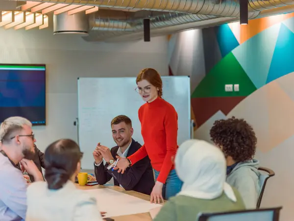 A diverse team of business experts in a modern glass office, attentively listening to a colleagues presentation, fostering collaboration and innovation.