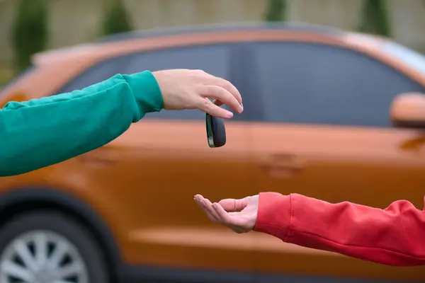 Car keys handshake, seller or car salesman and customer in a dealership, shake hands over the car keys and seal the purchase of the auto or new car.