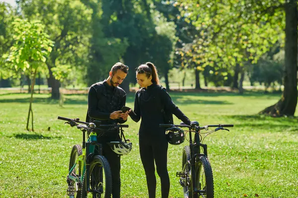 一对心地善良的夫妇 骑着自行车 专心致志地协调他们的旅行 一边检查他们的Gps手机和手表 一边在公园里规划风景线 完美地融合了各种技术和技术 — 图库照片