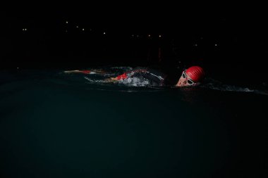 Kararlı bir profesyonel triatloncu soğuk sularda sıkı bir gece eğitimi alır. Yaklaşan triatlon yüzme yarışmasına hazırlanmak için kendini adamış ve direnç göstermiştir.. 