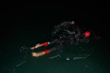 Kararlı bir profesyonel triatloncu soğuk sularda sıkı bir gece eğitimi alır. Yaklaşan triatlon yüzme yarışmasına hazırlanmak için kendini adamış ve direnç göstermiştir.. 