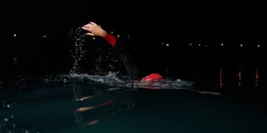 Kararlı bir profesyonel triatloncu soğuk sularda sıkı bir gece eğitimi alır. Yaklaşan triatlon yüzme yarışmasına hazırlanmak için kendini adamış ve direnç göstermiştir.. 