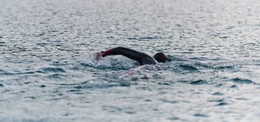 Profesyonel bir triatloncu gölde yapılacak yarışmaya kendini adamış, atletizm ve mükemmelliğe büyük bir bağlılık duygusu besliyor.