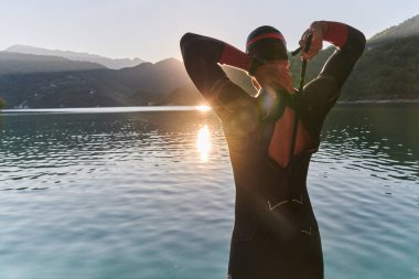 Otantik triatlon atleti gölde yüzme antrenmanına hazırlanıyor. Yüksek kalite fotoğraf