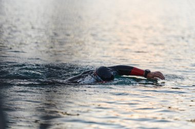 Profesyonel bir triatloncu gölde yapılacak yarışmaya kendini adamış, atletizm ve mükemmelliğe büyük bir bağlılık duygusu besliyor.