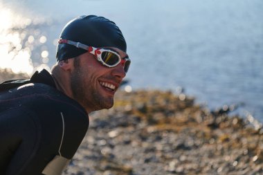 Otantik triatlon atleti gölde yüzme antrenmanına hazırlanıyor. Yüksek kalite fotoğraf