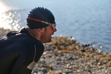 Otantik triatlon atleti gölde yüzme antrenmanına hazırlanıyor. Yüksek kalite fotoğraf
