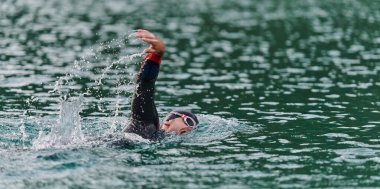 Profesyonel bir triatloncu gölde yapılacak yarışmaya kendini adamış, atletizm ve mükemmelliğe büyük bir bağlılık duygusu besliyor.