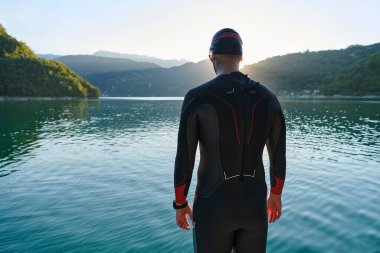 Otantik triatlon atleti gölde yüzme antrenmanına hazırlanıyor. Yüksek kalite fotoğraf