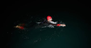 Kararlı bir profesyonel triatloncu soğuk sularda sıkı bir gece eğitimi alır. Yaklaşan triatlon yüzme yarışmasına hazırlanmak için kendini adamış ve direnç göstermiştir.. 