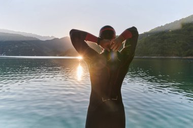 Otantik triatlon atleti gölde yüzme antrenmanına hazırlanıyor. Yüksek kalite fotoğraf
