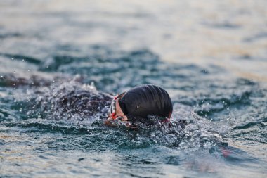 Profesyonel bir triatloncu gölde yapılacak yarışmaya kendini adamış, atletizm ve mükemmelliğe büyük bir bağlılık duygusu besliyor.