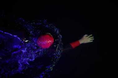 Gerçek bir triatlet yüzücüsüdür. Gölde, neon renkli ışıklarda sıkı bir antrenman sırasında mola verir.