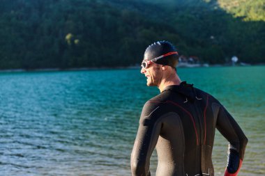 Otantik triatlon atleti gölde yüzme antrenmanına hazırlanıyor. Yüksek kalite fotoğraf