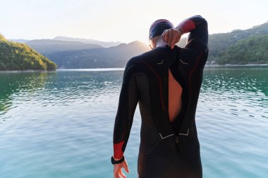 Otantik triatlon atleti gölde yüzme antrenmanına hazırlanıyor. Yüksek kalite fotoğraf