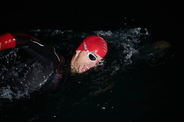 Kararlı bir profesyonel triatloncu soğuk sularda sıkı bir gece eğitimi alır. Yaklaşan triatlon yüzme yarışmasına hazırlanmak için kendini adamış ve direnç göstermiştir.. 