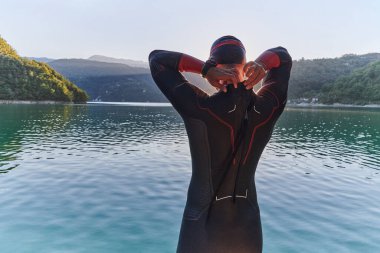 Otantik triatlon atleti gölde yüzme antrenmanına hazırlanıyor. Yüksek kalite fotoğraf