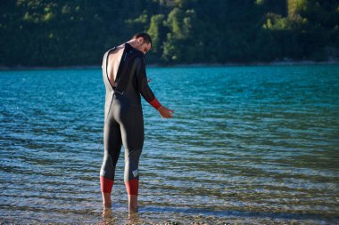 Otantik triatlon atleti gölde yüzme antrenmanına hazırlanıyor. Yüksek kalite fotoğraf