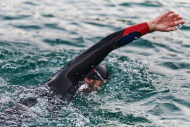 Profesyonel bir triatloncu gölde yapılacak yarışmaya kendini adamış, atletizm ve mükemmelliğe büyük bir bağlılık duygusu besliyor.