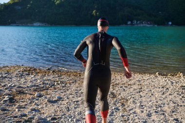 Otantik triatlon atleti gölde yüzme antrenmanına hazırlanıyor. Yüksek kalite fotoğraf