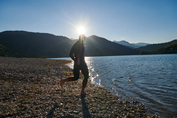 Triathlon athlete starting swimming training on lake.