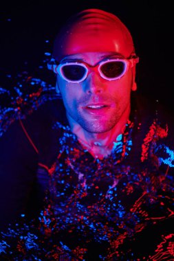 Gerçek bir triatlet yüzücüsüdür. Gölde, neon renkli ışıklarda sıkı bir antrenman sırasında mola verir.