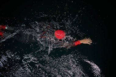 Kararlı bir profesyonel triatloncu soğuk sularda sıkı bir gece eğitimi alır. Yaklaşan triatlon yüzme yarışmasına hazırlanmak için kendini adamış ve direnç göstermiştir.. 