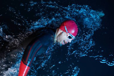 Kararlı bir profesyonel triatloncu soğuk sularda sıkı bir gece eğitimi alır. Yaklaşan triatlon yüzme yarışmasına hazırlanmak için kendini adamış ve direnç göstermiştir.. 