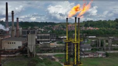 Bir kimya fabrikasında meşale yakmak. Zararlı maddelerin atmosfere salınımı. Kimya endüstrisinde Ateşli Baca. Sinematik Hava Aracı Kurma Paraşütü Çekimi. 