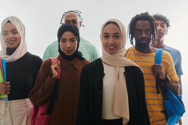 Eğitimsel çeşitliliğin canlı bir gösterimiyle, bir grup öğrenci, sırt çantaları, dizüstü bilgisayarlar ve tabletlerle, modern teknolojinin bir karışımını sembolize ederek, temiz beyaz bir arkaplana karşı poz veriyor.