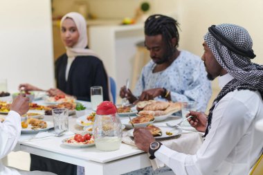 Geleneksel ve çeşitli Müslüman bir aile kutsal Ramazan ayında, aile neşesi, kültürel zenginlik ve ruhsal birliğin özünü somutlaştıran lezzetli bir iftar yemeğini paylaşmak için bir araya geliyor.