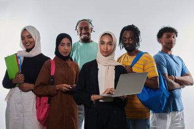 Çeşitli öğrencilerden oluşan bir grup, temiz beyaz bir arkaplana karşı dizüstü bilgisayarlar, tabletler ve akıllı telefonlar gibi çeşitli teknolojik araçlardan yararlanarak modern eğitim uygulamalarına girişiyor.