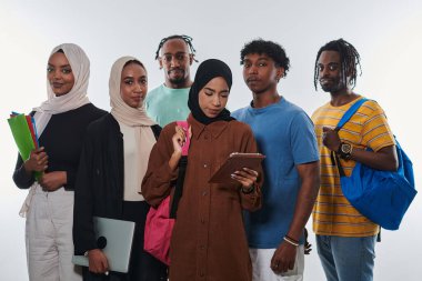 Çeşitli öğrencilerden oluşan bir grup, temiz beyaz bir arkaplana karşı dizüstü bilgisayarlar, tabletler ve akıllı telefonlar gibi çeşitli teknolojik araçlardan yararlanarak modern eğitim uygulamalarına girişiyor.