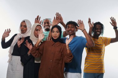 Coşkulu ve çeşitli bir grup, Afrika kökenli Amerikalı bir adam ve tesettürlü kızlar, coşkuyla el sallıyor ve kutluyorlar, öğrenci yaşamının canlılığını somutlaştırıyorlar, beyaz bir arka plana karşı,