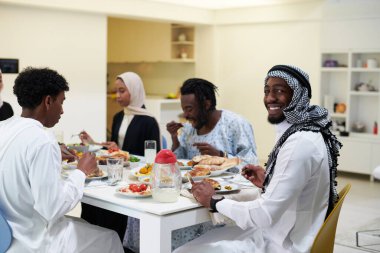 Geleneksel ve çeşitli Müslüman bir aile kutsal Ramazan ayında, aile neşesi, kültürel zenginlik ve ruhsal birliğin özünü somutlaştıran lezzetli bir iftar yemeğini paylaşmak için bir araya geliyor.