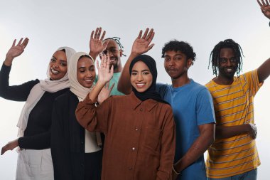 Coşkulu ve çeşitli bir grup, Afrika kökenli Amerikalı bir adam ve tesettürlü kızlar, coşkuyla el sallıyor ve kutluyorlar, öğrenci yaşamının canlılığını somutlaştırıyorlar, beyaz bir arka plana karşı,