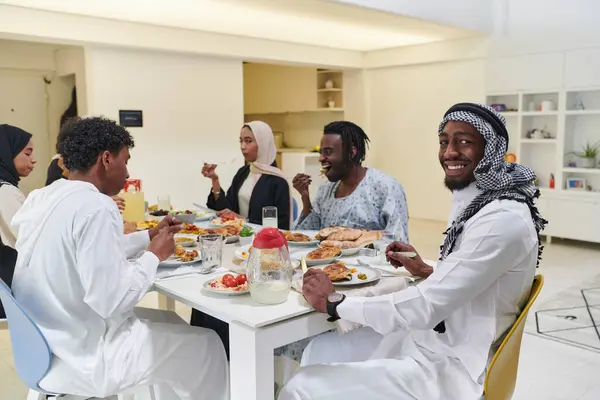 伝統的で多様なイスラム教徒の家族が集まって ラマダンの神聖な月の間に美味しいイフタール料理を共有し 家族の喜び 文化的豊かさ 精神的な統一の本質を体現しています — ストック写真