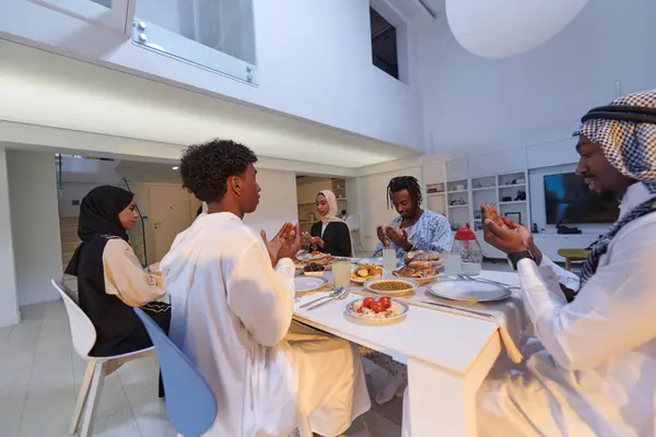 In the sacred month of Ramadan, a diverse Muslim family comes together in spiritual unity, fervently praying to God before breaking their fast, capturing a moment of collective devotion, cultural